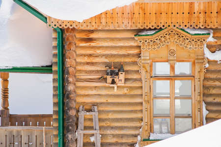 Starling house with birds on a wall of a wooden building in winter, Russiaの写真素材