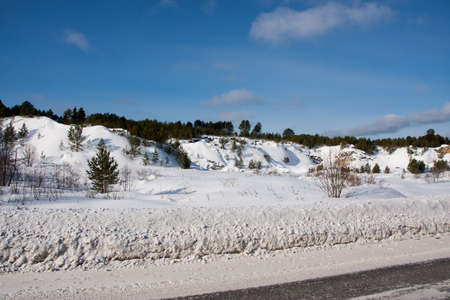 Winter landscape with mountains and road in the forestの写真素材