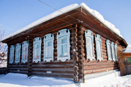 Wooden house in the village winter sunny day, Sverdlovsk region, Russiaの写真素材