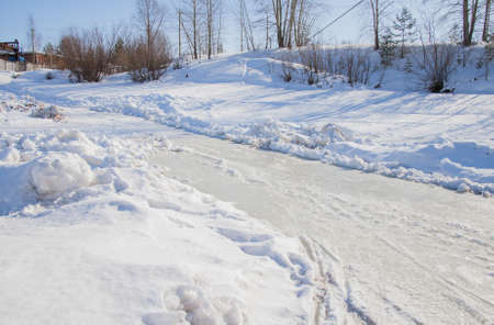 Winter landscape with an ice footpath and treesの写真素材