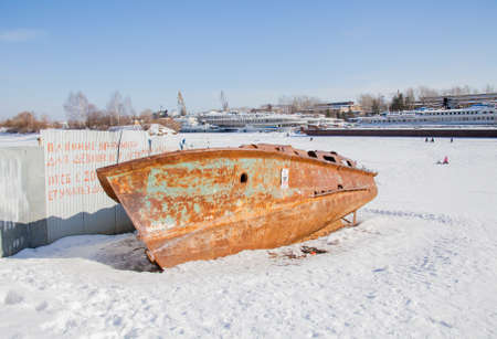 Perm, Russia - March 11.2017: The rusty boat hull on a winter day lies on the snow in the backwaters of the Kama Riverのeditorial素材