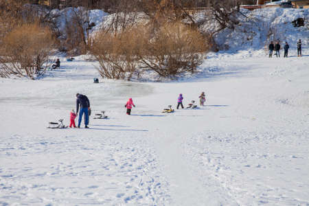 Perm, Russia - March 11.2017: Children ride a slide in the winter in the backwaters of the Kama riverのeditorial素材
