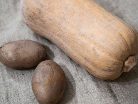 pumpkin and a few potatoes on wooden backgroundの写真素材