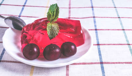 Strawberry jelly on the plate with ripe cherries.の写真素材