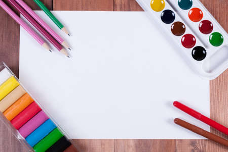 sheet of paper and the underlying paint the corners, pencils, markers and plasticine. top viewの写真素材