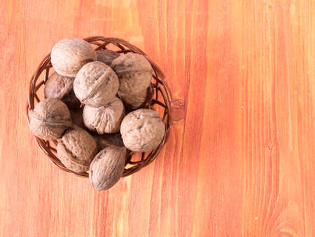 Walnuts in a basket on wooden background.の写真素材