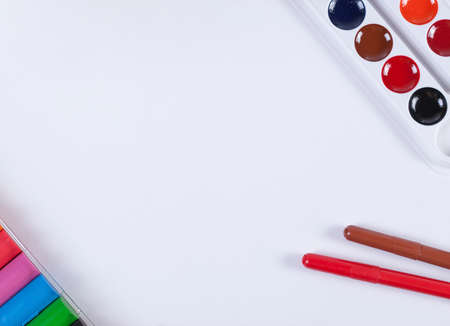 A set of children's watercolors to a set of plasticine on a white background