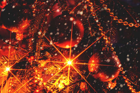 Christmas ornaments and garland on the Christmas tree with stars from the lamps. the falling snowflakes. Vintage.の写真素材