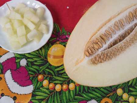 Cutting a melon and juicy melon slices on a white plateの写真素材