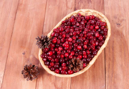 Basket with ripe cranberries on a wooden backgroundの写真素材