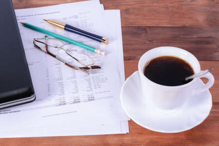 Computer laptop with notebooks, pen, pencil coffee cup on desk, business concept