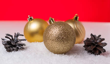 Christmas tree bump and yellow Christmas tree ball on snowの写真素材