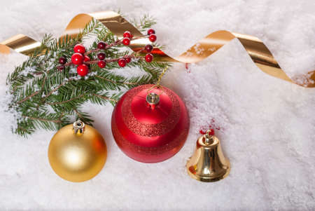 Christmas balls, fir-tree branch, bell and ribbon of serpentine on the snow. View from above. の写真素材