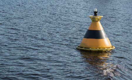 Warning vessel striped buoy in the waterの写真素材