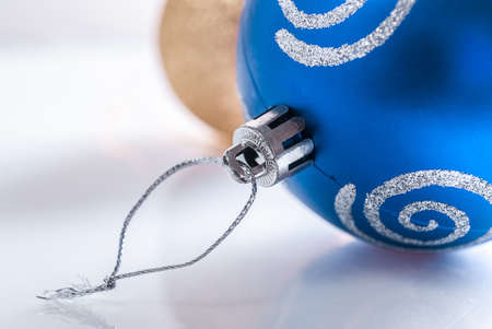 Blue and yellow Christmas balls on the snow. Close-up. Focus on the front ballの写真素材
