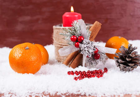 New Year's composition with a red candle in a candlestick, mandarins, a New Year's decor.の写真素材