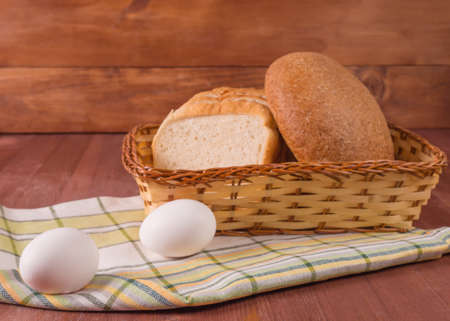 Basket with white bread and egg on a napkinの写真素材