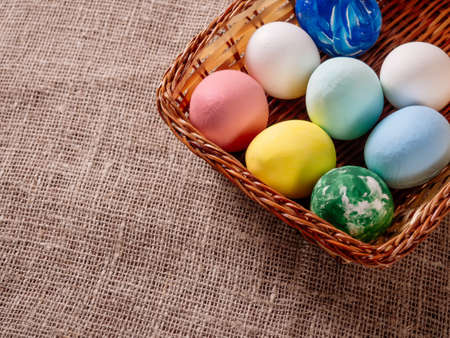 Easter eggs in a wicker basket on a canvas backgroundの写真素材