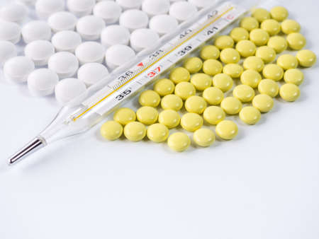 thermometer and many tablets close-up on a white backgroundの写真素材