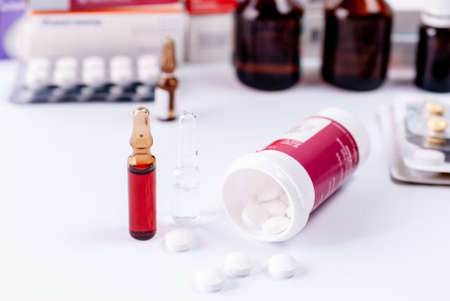 Ampoules for injection, packing of tablets and medical bottles on a white tableの写真素材