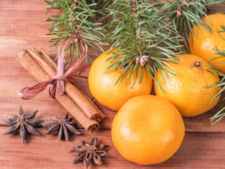 Christmas concept with Tangerines, Fir branches with spices on the old rustic wooden table.の写真素材