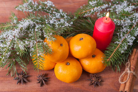 Card with mandarins, red candle, cones and cinnamon starsの写真素材