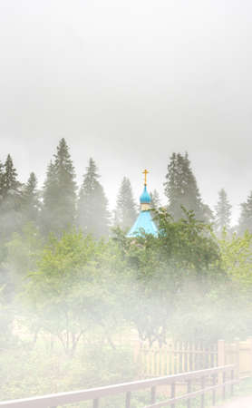 Blue dome of a wooden church in the fogの写真素材