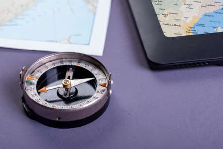 Close-up of old compass, tablet and map