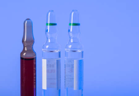 Three ampoules for medical injection in blue lightの写真素材