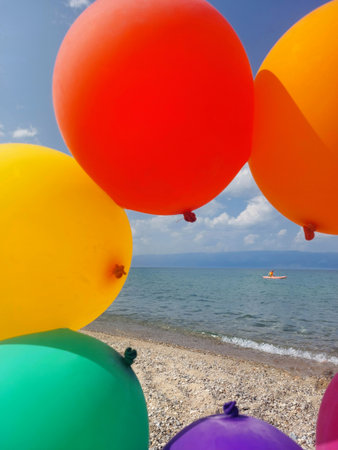 Colorful balloons on the beach at sunny day, closeup of photoの写真素材