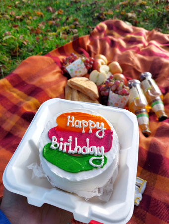 Birthday cake on a picnic in the park. Happy birthday.の写真素材