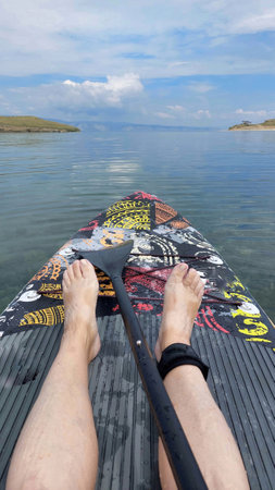 Paddle boarding on a lake,bare feet,an oar,a view of the bay.の写真素材