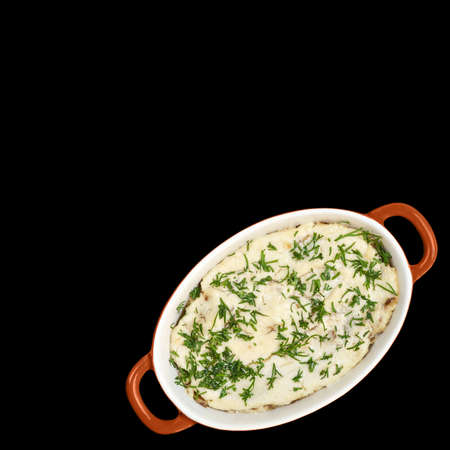 Mushrooms, baked in sour cream with dill in a ceramic dish for baking isolated on black backgroundの写真素材