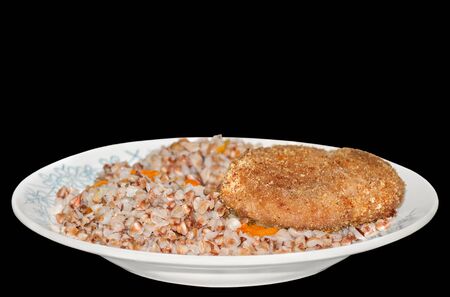 Buckwheat porridge with meat Patty on the plate, isolated on black backgroundの写真素材