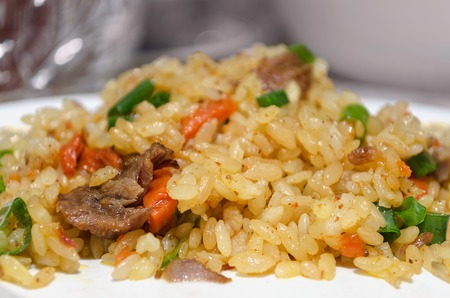 Uzbek pilaf on a platter, close-up and bokehの写真素材