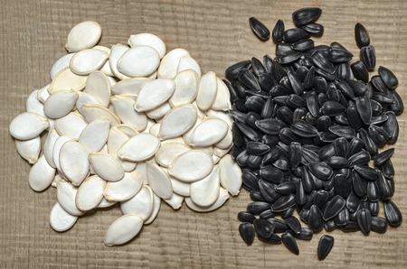 Pumpkin seeds and sunflower seeds, lying on the wooden background is not clearedの写真素材