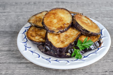 Fried eggplant on a plate and gray wood background, rusticの写真素材