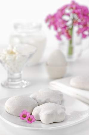 Gingerbread, eggs, curd and milk for Breakfast. White background, high key, selective focus. Pink flowersの写真素材