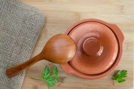 Ceramic indoor pot and a wooden spoon. The view from the top.の写真素材