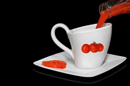 Freshly prepared tomato juice poured into a gravy boat. Black background.の写真素材