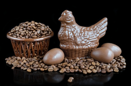 Beans coffee and chocolate in the form of chicken and eggs on a black backgroundの写真素材