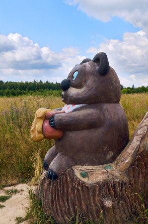 Berendeyevo, Russia, Moscow region, 26 July , 2014, summer landscape with fabulous sculptures. Bear with a honey pot sitting on a stump. Public Park.のeditorial素材