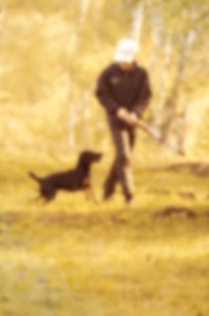 Abstract blurred image of nature, and man with a dog on a walk to use the background.
