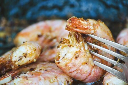 Fried shrimp with spices on a fork. Macro, selective focusの写真素材