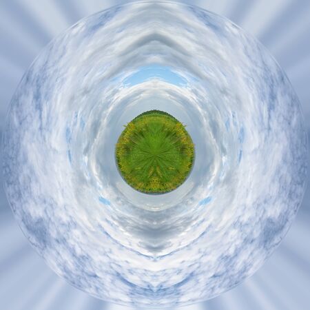 A planet with a blooming green meadow and clouds in a blue sky