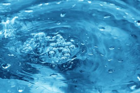 Blue shiny liquid with bubbles on the surface.