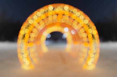 Defocused lights holiday lighting in the winter city, the arch of the side