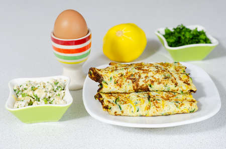 Delicious omelet with a filling of cheese, zucchini and chopped greens. Selective focus