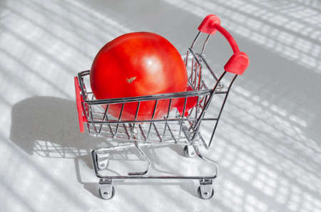 Concept of buying vegetables, ripe red tomatoes in the grocery basket. Selective focusの写真素材