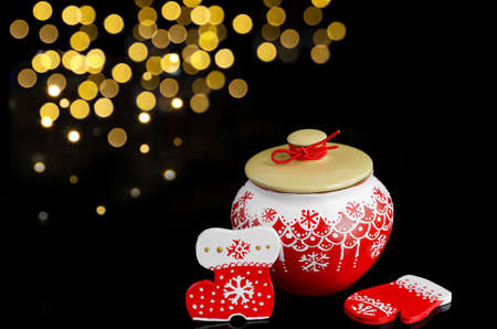 Christmas set with a pot and wooden ornaments in red on a black background with bokehの写真素材